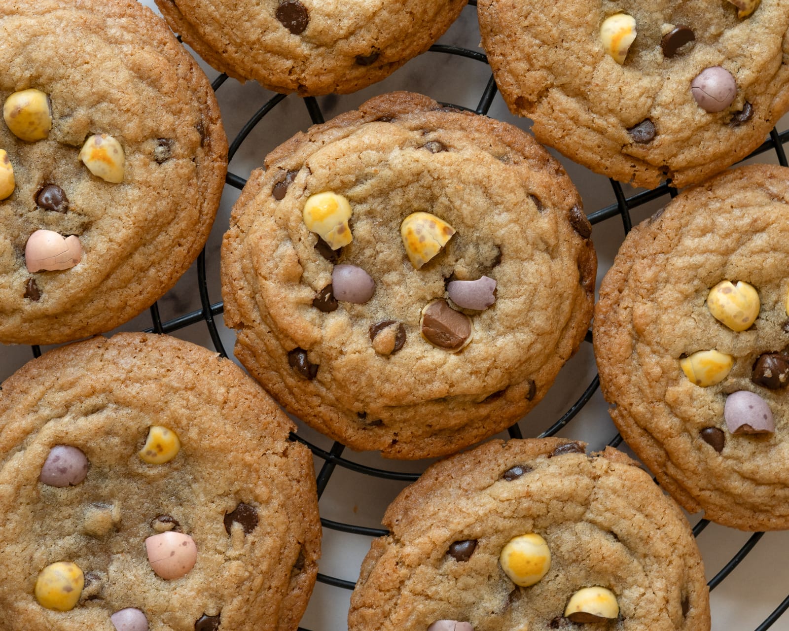 Close-up of chocolate chip cookies with mini Easter eggs on cooling rack
